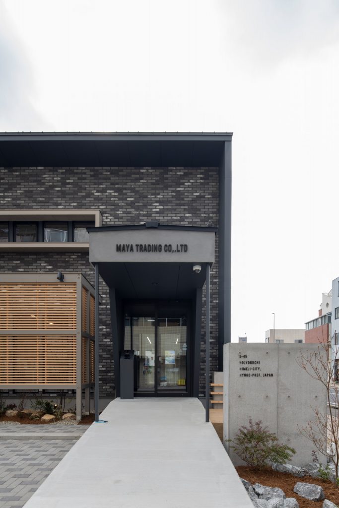 喧騒のオアシス社屋のシックでモダンなファサードとコンクリート門柱のあるオシャレな外観