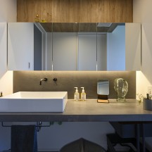 間接照明と3面鏡のあるホテルライクなモールテックス造作洗面台